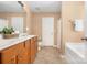 Main bathroom boasts double sinks, warm wood cabinets and flooring, and neutral walls at 128 Lacona Trce, Mooresville, NC 28115