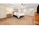 Spacious main bedroom with tray ceiling, fan, carpet flooring, and natural light at 128 Lacona Trce, Mooresville, NC 28115