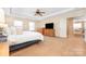 Spacious main bedroom with tray ceiling, fan, carpet flooring, and natural light at 128 Lacona Trce, Mooresville, NC 28115
