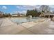 Community pool with a safety cover, surrounded by a spacious deck, providing a secure recreational area at 128 Lacona Trce, Mooresville, NC 28115