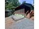 Backyard view showcasing a cozy screened-in porch, rock landscaping, and a storage shed at 152 Muskhogean Way, Mount Gilead, NC 27306