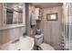 Bright bathroom features a white vanity, toilet, and woven mirror at 152 Muskhogean Way, Mount Gilead, NC 27306
