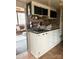 This cozy kitchenette has white cabinets, a dark sink, and overlooks the screened porch at 152 Muskhogean Way, Mount Gilead, NC 27306