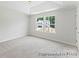 Bedroom with neutral carpet, tray ceiling, and a view of the neighborhood at 156 Tangle River Dr # 35, Statesville, NC 28677