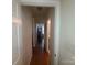 This hallway features doors, tan walls, and dark wood floors at 1638 Bess Town Rd, Bessemer City, NC 28016