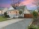 Charming white home with a red door, a cozy front porch, and a gravel driveway at 1921 Union St, Charlotte, NC 28205
