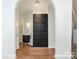Arched hallway featuring hardwood floors, a storage cabinet, and a hall bathroom with a floating vanity sink at 1921 Union St, Charlotte, NC 28205