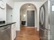 Bright kitchen featuring stainless steel appliances, wooden floors, granite counters, and an arched entrance to the hall bathroom at 1921 Union St, Charlotte, NC 28205