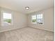 Bright, carpeted bedroom with two windows offering ample natural light and neighborhood views at 2211 Camber Dr # Cwo0103, Gastonia, NC 28054
