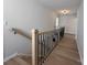 Hallway view featuring wood flooring and modern black metal staircase railing at 2211 Camber Dr # Cwo0103, Gastonia, NC 28054