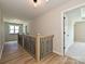 Hallway with wood-look floors, wooden railing with metal spindles and natural light at 2211 Camber Dr # Cwo0103, Gastonia, NC 28054