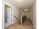 Hallway with wood-look floors and wooden railing with metal spindles, great natural light at 2211 Camber Dr # Cwo0103, Gastonia, NC 28054