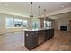 Bright kitchen boasts a large island with seating and stainless appliances plus views into the dining area at 2211 Camber Dr # Cwo0103, Gastonia, NC 28054