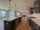 Gourmet kitchen featuring dark cabinets, quartz countertops, stainless appliances, and an open view to the living room at 2211 Camber Dr # Cwo0103, Gastonia, NC 28054