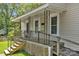 Inviting front porch featuring detailed railings, a small seating area, and convenient ramp access at 225 Institute St, Mooresville, NC 28115