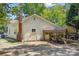 Home exterior featuring a shaded carport, brick chimney, and a spacious yard with convenient parking at 225 Institute St, Mooresville, NC 28115