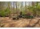 Lush backyard featuring mature trees, stone bench, and a tranquil water feature at 225 Riverton Rd, Weddington, NC 28104