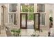 Bright foyer with decorative plants, a chair, and a view of the outdoors through the stylish front door at 225 Riverton Rd, Weddington, NC 28104