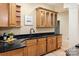 Modern kitchen with dark countertops, wooden cabinets, and a sleek black faucet, creating a sophisticated culinary space at 225 Riverton Rd, Weddington, NC 28104