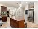 Open kitchen with large island, stainless steel refrigerator, granite counters, and views into the dining area at 225 Riverton Rd, Weddington, NC 28104