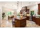 Open kitchen with a large granite island, stainless steel appliances, and a dining area with natural light at 225 Riverton Rd, Weddington, NC 28104