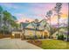 Charming two-story home featuring a manicured lawn, stone accents, and an attached two-car garage at 3288 Sherman Dr, Lancaster, SC 29720