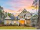 Beautiful two-story home featuring stone accents, manicured lawn, and a welcoming front porch at sunset at 3288 Sherman Dr, Lancaster, SC 29720