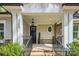 Inviting front porch with stone accents, black railing, and an oval window feature at 3288 Sherman Dr, Lancaster, SC 29720