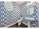 Stylish powder room featuring patterned wallpaper, pedestal sink, and oval mirror at 3288 Sherman Dr, Lancaster, SC 29720