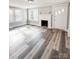 Bright living room featuring updated windows, luxury vinyl plank flooring, and a fireplace at 32884 Old Salisbury Rd, Albemarle, NC 28001