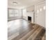 Sunlit living room featuring a decorative fireplace, large windows, and new floors at 32884 Old Salisbury Rd, Albemarle, NC 28001