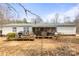Backyard of the home with a deck, patio, and grassy area, offering a functional outdoor space at 390 Rocky Rick Rd, Rockwell, NC 28138