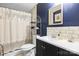 Stylish bathroom with silver shower curtain, dark blue walls, modern shelving, and white countertops, creating a sleek design at 390 Rocky Rick Rd, Rockwell, NC 28138