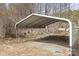 A large metal carport with a gravel driveway in a wooded area at 390 Rocky Rick Rd, Rockwell, NC 28138