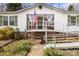Single-story home with a ramp, front porch with chairs, and a well-maintained lawn at 390 Rocky Rick Rd, Rockwell, NC 28138