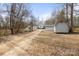 Wide exterior shot of the home with storage building and a grassy yard at 390 Rocky Rick Rd, Rockwell, NC 28138