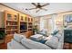 Bright living room features built-in wooden shelving, comfortable gray seating, and natural light from large windows at 390 Rocky Rick Rd, Rockwell, NC 28138
