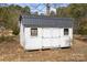 A white shed with a black roof sits on a gravel lot at 390 Rocky Rick Rd, Rockwell, NC 28138