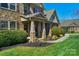 Inviting front porch with stone columns, a cozy seating area, and manicured landscaping at 4004 Tremont Dr, Indian Trail, NC 28079