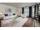 Bright living room featuring a plush white sofa, modern decor, and hardwood floors at 521 N Graham St # 2B, Charlotte, NC 28202