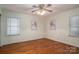 Bright bedroom with hardwood floors, ceiling fan, and two windows providing natural light and comfort at 816 S Point Rd, Belmont, NC 28012