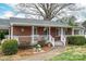 Inviting covered front porch featuring brick facade, white railing, and a bench at 816 S Point Rd, Belmont, NC 28012