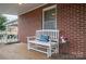 Front porch with a white bench and a small table with flowers at 816 S Point Rd, Belmont, NC 28012