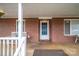 Cozy covered front porch with brick facade, white railing, and comfortable seating at 816 S Point Rd, Belmont, NC 28012