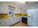 Well-lit kitchen with white cabinets, appliances, and vintage yellow countertop at 816 S Point Rd, Belmont, NC 28012