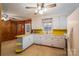Retro kitchen with white cabinets, yellow countertops, and wood-paneled walls, creating a unique vintage charm at 816 S Point Rd, Belmont, NC 28012