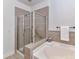 Bathroom boasting a clear glass-enclosed shower and a garden bathtub at 8925 Rosalyn Glen Rd, Cornelius, NC 28031