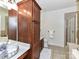 Bathroom featuring brown cabinets, a white toilet, and a glass-doored shower at 8925 Rosalyn Glen Rd, Cornelius, NC 28031