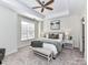 Calming main bedroom featuring a tray ceiling, neutral decor, and ensuite bathroom at 8925 Rosalyn Glen Rd, Cornelius, NC 28031