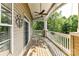 This outdoor porch has a ceiling fan and white railings with decorative columns at 8925 Rosalyn Glen Rd, Cornelius, NC 28031